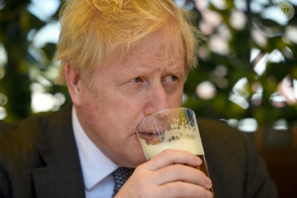 Le Premier ministre britannique Boris Johnson s'entretient avec des clients du pub "The Mount" à Wolverhampton, à propos de la campagne électorale locale, le 19 avril 2021.
