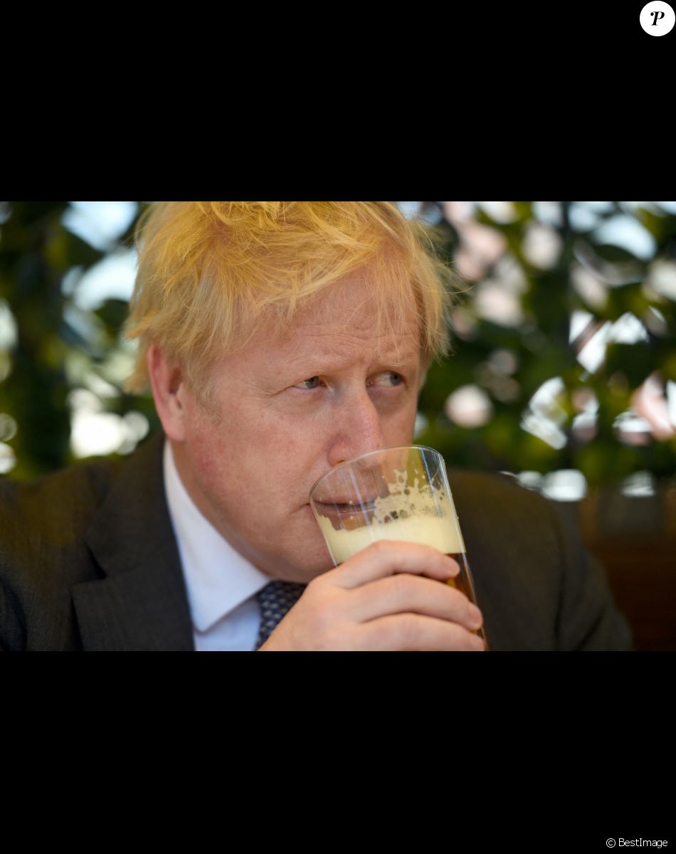 Le Premier ministre britannique Boris Johnson s'entretient avec des clients du pub "The Mount" à Wolverhampton, à propos de la campagne électorale locale, le 19 avril 2021.