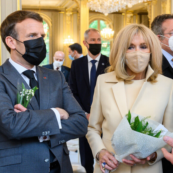 Le président de la République française Emmanuel Macron et sa femme la Première dame Brigitte Macron lors de la traditionnelle cérémonie du muguet du 1er Mai au palais de l'Elysée à Paris, France, le 1er 2021. © Jacques Witt/Pool/Bestimage 