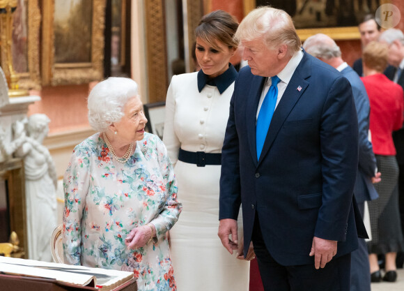 Le président Donald J. Trump et la première dame Melania Trump examinent des articles de la collection royale avec la reine Elisabeth II d'Angleterre, dans la galerie de peintures du palais de Buckingham à Londres le lundi 3 juin 2019