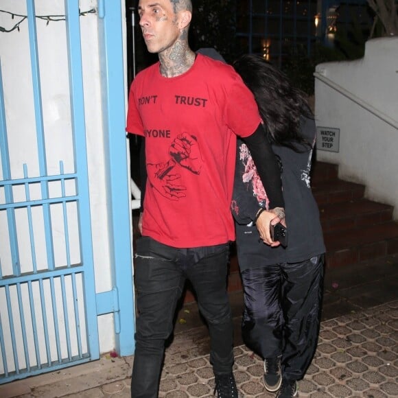 Exclusif - Kourtney Kardashian se cache des photographes derrière son compagnon Travis Barker à la sortie d'un diner à Los Angeles, le 12 juillet 2021 