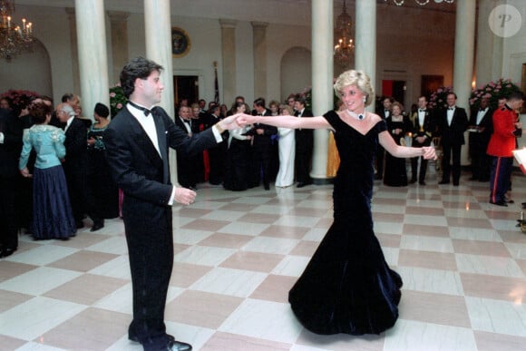 Lady Diana (dans sa robe en velours Victor Edelstein) et John Travolta lors du dîner officiel organisé à la Maison-Blanche par le président américain Ronald Reagan 
