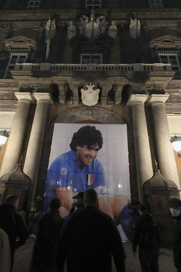 Décès de Diego Maradona : Des supporters se rassemblent devant un portrait du joueur sur la place del Plebiscito à Naples le 26 novembre 2020.