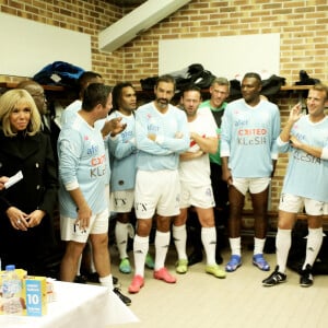 Jacques Vendroux, le manager général du Variété Club de France, La Première Dame Brigitte Macron, Karl Olive, le maire de Poissy, Christian Karembeu, Robert Pirès, Nicolas Douchez, Marcel Desailly, le président de la République Emmanuel Macron, Arsène Wenger et Laure Boulleau dans les vestiaires avant de participer au match de football caritatif, au profit de la Fondation Hôpitaux de Paris-Hôpitaux de France dans la cadre de l'opération "Pièces jaunes", présidée par la Première Dame, opposant le Variétés Club de France à une sélection de soignants du centre hospitalier intercommunal de Poissy Saint-Germain-en-Laye, au stade Léo-Lagrange à Poissy, Yvelines, France, le 14 octobre 2021. Le président de la République Emmanuel Macron sera aligné au poste de milieu défensif avec un maillot floqué du numéro 3 pour la rencontre du Variétés Club de France. © Dominique Jacovides/Bestimage