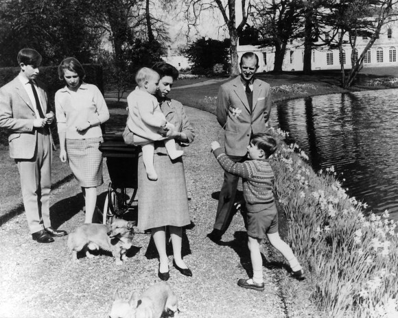 La reine Elisabeth II d'Angleterre, le prince Philip, duc d'Edimbourg, et leurs enfants, le prince Charles, la princesse Anne, le prince Edward et le prince Andrew promènent leurs corgis, en 1965.