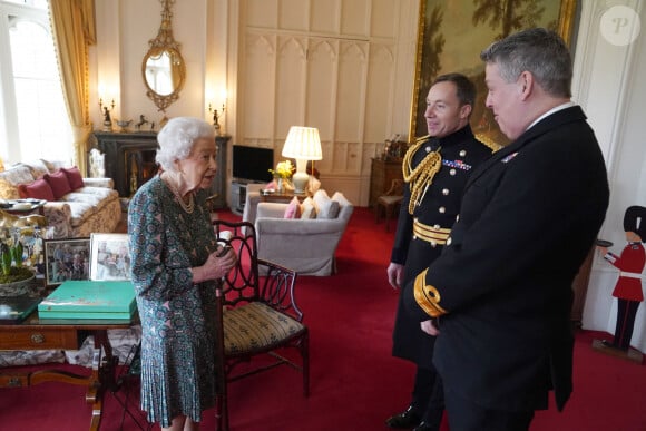 La reine Elisabeth II d'Angleterre en audience avec l'Amiral James Macleod et le Général Eldon Millar au château de Windsor.