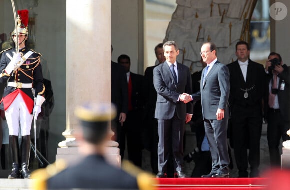 Passation de pouvoir entre Nicolas Sarkozy et François Hollande, accompagnés de leur bien-aimées Carla Bruni-Sarkozy et Valérie Trierweiler, le 15 mai 2012 sur le perron de l'Elysée