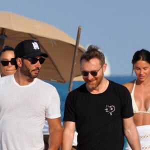 David Guetta et sa compagne Jessica Ledon, avec son ami le DJ Cédric Gervais et sa fiancée Adriana Gutierrez, sur la plage du palace Setai à Miami, le 20 mars 2022.