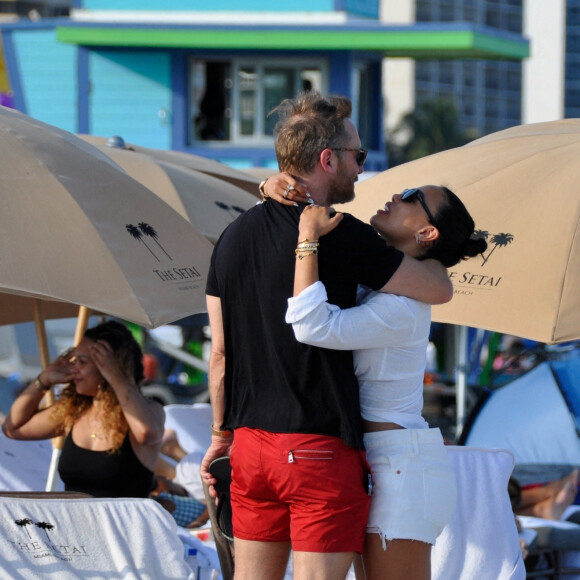 David Guetta et sa compagne Jessica Ledon, avec son ami le DJ Cédric Gervais et sa fiancée Adriana Gutierrez, sur la plage du palace Setai à Miami, le 20 mars 2022.