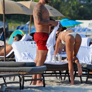 David Guetta et sa compagne Jessica Ledon, avec son ami le DJ Cédric Gervais et sa fiancée Adriana Gutierrez, sur la plage du palace Setai à Miami, le 20 mars 2022.