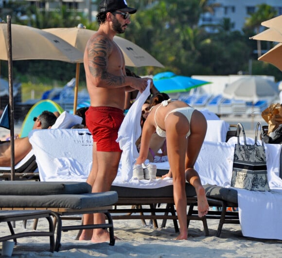 David Guetta et sa compagne Jessica Ledon, avec son ami le DJ Cédric Gervais et sa fiancée Adriana Gutierrez, sur la plage du palace Setai à Miami, le 20 mars 2022.