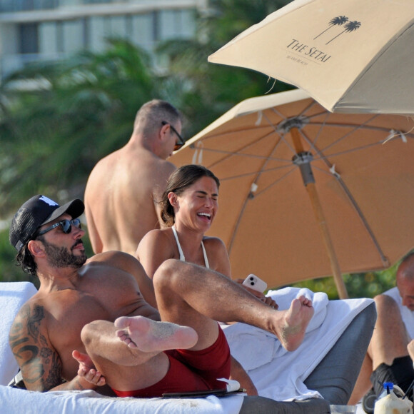 David Guetta et sa compagne Jessica Ledon, avec son ami le DJ Cédric Gervais et sa fiancée Adriana Gutierrez, sur la plage du palace Setai à Miami, le 20 mars 2022.