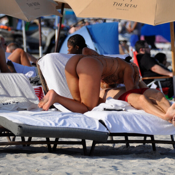 David Guetta et sa compagne Jessica Ledon, avec son ami le DJ Cédric Gervais et sa fiancée Adriana Gutierrez, sur la plage du palace Setai à Miami, le 20 mars 2022.