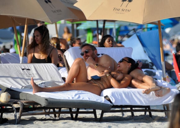 David Guetta et sa compagne Jessica Ledon, avec son ami le DJ Cédric Gervais et sa fiancée Adriana Gutierrez, sur la plage du palace Setai à Miami, le 20 mars 2022.