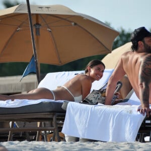 David Guetta et sa compagne Jessica Ledon, avec son ami le DJ Cédric Gervais et sa fiancée Adriana Gutierrez, sur la plage du palace Setai à Miami, le 20 mars 2022.