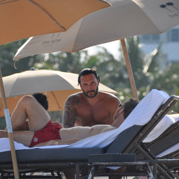 David Guetta et sa compagne Jessica Ledon, avec son ami le DJ Cédric Gervais et sa fiancée Adriana Gutierrez, sur la plage du palace Setai à Miami, le 20 mars 2022.