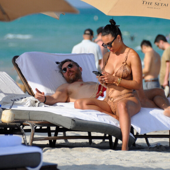 David Guetta et sa compagne Jessica Ledon, avec son ami le DJ Cédric Gervais et sa fiancée Adriana Gutierrez, sur la plage du palace Setai à Miami, le 20 mars 2022.