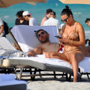 David Guetta et sa compagne Jessica Ledon, avec son ami le DJ Cédric Gervais et sa fiancée Adriana Gutierrez, sur la plage du palace Setai à Miami, le 20 mars 2022.