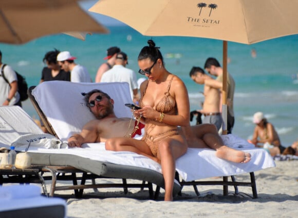 David Guetta et sa compagne Jessica Ledon, avec son ami le DJ Cédric Gervais et sa fiancée Adriana Gutierrez, sur la plage du palace Setai à Miami, le 20 mars 2022.