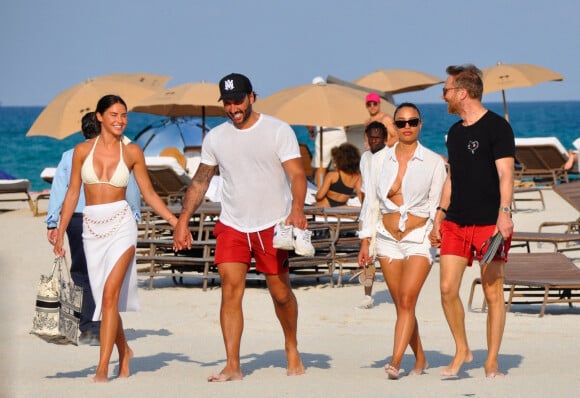 David Guetta et sa compagne Jessica Ledon, avec son ami le DJ Cédric Gervais et sa fiancée Adriana Gutierrez, sur la plage du palace Setai à Miami, le 20 mars 2022.