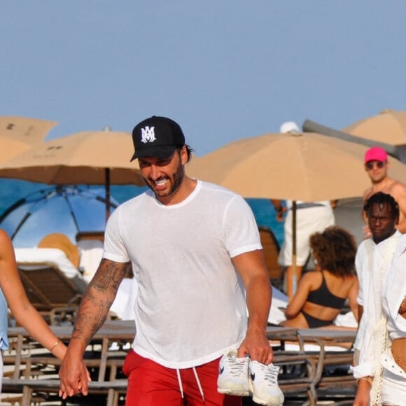 David Guetta et sa compagne Jessica Ledon, avec son ami le DJ Cédric Gervais et sa fiancée Adriana Gutierrez, sur la plage du palace Setai à Miami, le 20 mars 2022.