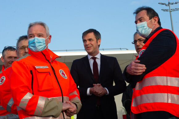 Olivier Véran, ministre de la santé avec des secouristes de la Croix Rouge, lors de l'accueil d'enfants ukrainiens malades, arrivés par un vol spécial, à l'aéroport de Orly le 21 mars 2022. © Eric Tschaen / Pool / Bestimage 