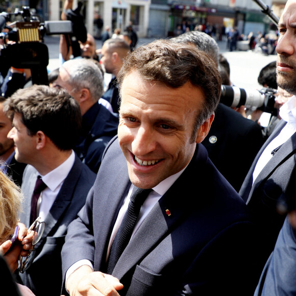 Le président de la République française et candidat du parti centriste La République en marche (LREM) à la réélection, Emmanuel Macron, s'entretient avec des habitants lors d'une visite de campagne dans la banlieue nord de Paris à Saint-Denis, Seine Saint-Denis, France, le 21 avril 2022