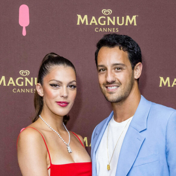 Iris Mittenaere (Miss France 2016) et son compagnon Diego El Glaoui au photocall de la soirée "Magnum" lors du 75ème Festival International du Film de Cannes le 19 mai 2022. Sur la plage Magnum Cannes, Kylie Minogue et peggy Gou dévoilent un grand classique remixé. Pour célébrer le lancement de la nouvelle gamme Magnum Remix, Magnum s'associe aux deux pionnières de la musique Kylie Minogue et Peggy Gou pour lancer une version arrangée du hit planétaire de la chanteuse, sorti en 2001 : " Can't Get You Out of My Head ". Le titre remixé ainsi que le clip vidéo ont été présentés aujourd'hui lors d'une session de questions-réponses, en direct du 75e Festival de Cannes. Sur la Croisette, Magnum célèbre une exclusivité mondiale ! La légendaire icône de la pop Kylie Minogue et la pionnière de la dance music sud-coréenne Peggy Gou ont rejoint Magnum cet après-midi à Cannes pour lancer la campagne " Classics Can Be Remixed " de Magnum. Vingt ans après la sortie du hit planétaire de la star australienne " Can't Get You Out of My Head ", la célèbre marque de crème glacée premium a collaboré avec le duo emblématique pour créer une version house et exaltante du titre, entièrement réarrangé. Une façon de rappeler au monde entier que les classiques peuvent être remixés, pour créer encore de belles émotions. Lors d'une interview animée en direct par Clara Amfo, présentatrice britannique de BBC Radio 1, le morceau remixé de Kylie Minogue – " Can't Get You Out of My Head (Peggy Gou's Midnight Remix) " – et son clip vidéo ont été révélés au monde. Le clip revisite la version originale : on y retrouve Kylie Minogue dans sa combinaison blanche emblématique, au volant d'une De Tomaso Mangusta jaune. Dans cette nouvelle proposition s'invitent les influences pop coréennes de Peggy Gou. Pour réaliser la vidéo, Magnum a travaillé avec Seo Inji, illustratrice basée à Séoul, qui a apporté son style unique, créant ainsi une version entièrement réinventée. © Jack Tribeca / Bestimage 