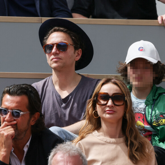 Mélanie Thierry et son compagnon le chanteur Raphael et leur fils Roman en tribunes lors des Internationaux de France de tennis de Roland Garros à Paris, France, le 26 mai 2022. 