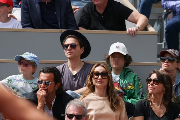 Mélanie Thierry et son compagnon le chanteur Raphael et leurs enfants Roman et Aliocha Haroche en tribunes lors des Internationaux de France de tennis de Roland Garros à Paris, France, le 26 mai 2022. 