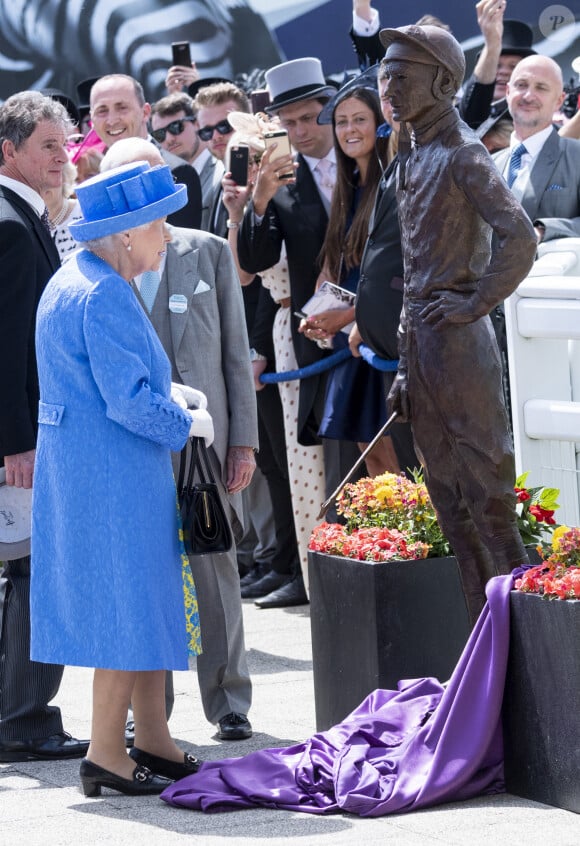 La reine Elisabeth II d'Angleterre dévoile une statue de Lester Piggott, lors du "Investec Derby Festival" sur le champ de cours d'Epsom, Surrey, Royaume Uni, le 1er juin 2019.