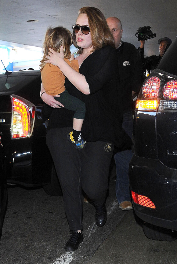 La chanteuse Adele et son fils Angelo Konecki arrivent à l'aéroport LAX de Los Angeles le 3 janvier 2015 entourés de nombreux photographes.