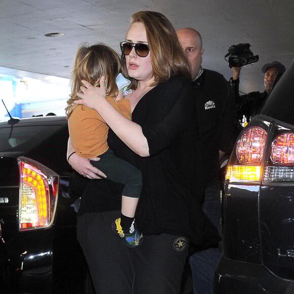La chanteuse Adele et son fils Angelo Konecki arrivent à l'aéroport LAX de Los Angeles le 3 janvier 2015 entourés de nombreux photographes.