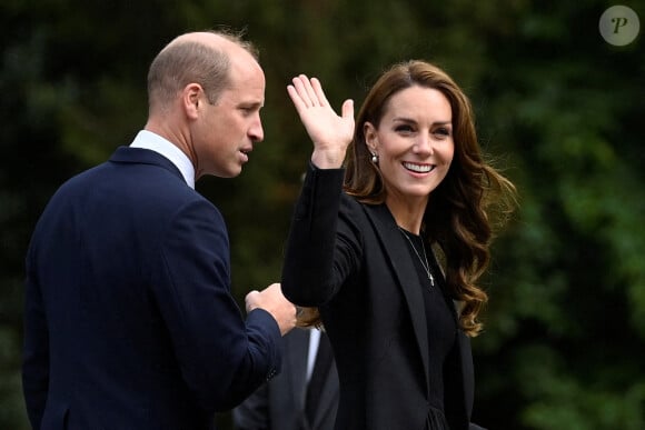 Le prince William, prince de Galles, et Catherine (Kate) Middleton, princesse de Galles regardent les hommages floraux laissés par les membres du public aux portes de Sandringham House à Norfolk, Royaume Uni, après la mort de la reine Elisabeth II.