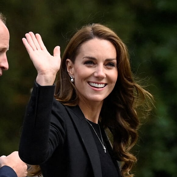 Le prince William, prince de Galles, et Catherine (Kate) Middleton, princesse de Galles regardent les hommages floraux laissés par les membres du public aux portes de Sandringham House à Norfolk, Royaume Uni, après la mort de la reine Elisabeth II.