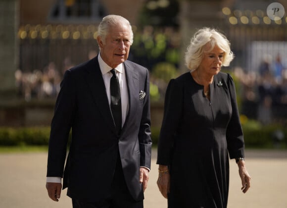 Le roi Charles III d'Angleterre et la reine consort Camilla Parker Bowles marchent le long des fleurs déposées en hommage à la reine Elisaberh II d'Angleterre, décédée le 8 septembre, devant le château de Hillsborough. Le 13 septembre 2022 
