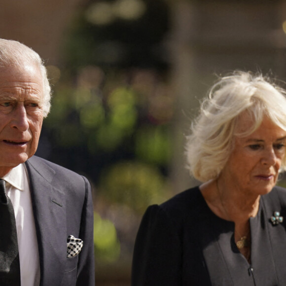 Le roi Charles III d'Angleterre et la reine consort Camilla Parker Bowles marchent le long des fleurs déposées en hommage à la reine Elisaberh II d'Angleterre, décédée le 8 septembre, devant le château de Hillsborough. Le 13 septembre 2022 