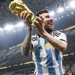 Joie de Lionel Messi (ARG) soulevant le trophee de la Coupe du Monde et porte en triomphe par ses coequipiers - Remise du trophée de la Coupe du Monde 2022 au Qatar (FIFA World Cup Qatar 2022) à l'équipe d'argentine après sa victoire contre la France en finale (3-3 - tab 2-4). Doha, le 18 décembre 2022. 