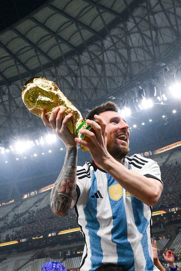 Joie de Lionel Messi (ARG) soulevant le trophee de la Coupe du Monde et porte en triomphe par ses coequipiers - Remise du trophée de la Coupe du Monde 2022 au Qatar (FIFA World Cup Qatar 2022) à l'équipe d'argentine après sa victoire contre la France en finale (3-3 - tab 2-4). Doha, le 18 décembre 2022. 