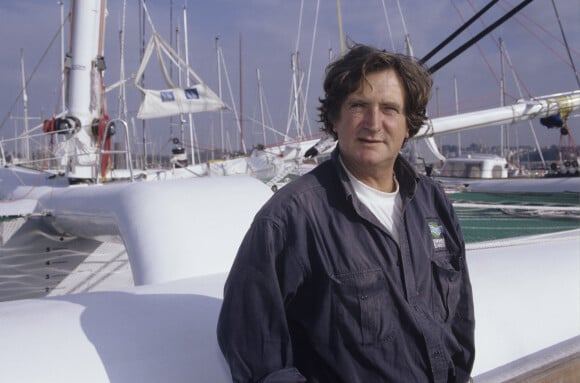 Archives - En France, à Brest, Olivier de Kersauson, sur le port de Brest, devant son voilier, un trimaran le 3 novembre 1995.