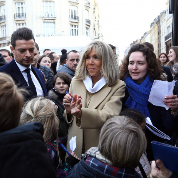 Brigitte Macron, Presidente de la Fondation des Hopitaux, signe des autographes aux enfants des ecoles lilloises. Pesée de toute la monnaie récoltée dans les fameuses tirelires pour clôturer de l’Opération Pièces Jaunes 2023 sur la place du théâtre à Lille, France, ce vendredi 3 février 2023 © Claude Dubourg/Bestimage