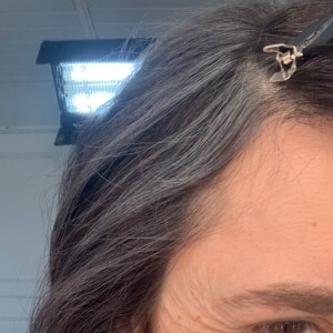 On peut en effet voir des rides naturelles et des cheveux grisonnants.
Églantine Éméyé vieillie pour un tournage.