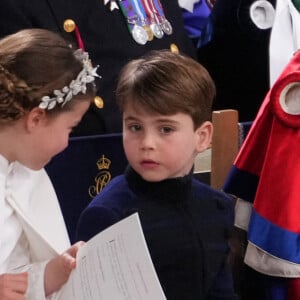 Dans la cathédrale, il a essayé de la déranger. 
La princesse Charlotte de Galles et le prince Louis de Galles - Les invités à la cérémonie de couronnement du roi d'Angleterre à l'abbaye de Westminster de Londres, Royaume Uni, le 6 mai 2023. 