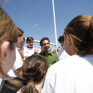 Mika - Le chanteur Mika devient le parrain de la Mêlée des Choeurs et rencontre, des élèves du CM1 à la Terminale qui interpréteront les hymnes nationaux des 48 matchs de la Coupe du Monde de Rugby 2023, à Gennevilliers, France, le 31 mai 2023. La coupe du monde de Rugby en France décroche une star internationale que la France adore en la personne de Mika pour un projet pédagogique et sociétal important unis par la musique. Mika devient le parrain de la Mêlée des Choeurs. Le projet de la Mêlée des Choeurs aura le privilège de compter sur un parrain d'exception : la popstar internationale Mika. La Coupe du Monde de Rugby 2023 a le plaisir d'annoncer que le chanteur Mika sera le parrain de la Mêlée des Choeurs, qui mobilise plus de 7 000 élèves du CM1 à la Terminale, à travers toute la France, pour interpréter les hymnes nationaux des 48 matchs de la Coupe du Monde de Rugby 2023. Artiste complet (auteur, compositeur et interprète) et engagé, véritable citoyen du monde, Mika a rencontré un triomphe planétaire dès 2007, avec l'album Life in Cartoon Motion – les tubes Relax, Take It Easy, Grace Kelly ou encore Love Today en sont extraits – certifié disque de diamant et vendu à plus de 6 millions d'exemplaires partout dans le monde. Suivront quatre nouveaux albums et une farandole de hits qui ont conquis les coeurs, en France comme à l'international : We Are Golden, Rain, Elle me dit, Boum Boum Boum ou encore Keep it simple, sorti en 2023 en duo avec Vianney. 7 000 élèves mobilisés partout en FranceLa collaboration entre Mika et la Mêlée des Choeurs démarrera dès demain, à l'occasion des 100 jours de la Coupe du Monde de Rugby 2023, avec une rencontre organisée avec de jeunes choristes en région parisienne, en présence également d'un Champion du Monde de Rugby. Lancé de concert avec le ministère de l'Education nationale, le ministère de la Culture et la Maîtrise populaire de l'Opéra-Comique, la Mêlée des Choeurs est un projet innovant, à triple dimension artistique, pédagogique et événementielle. Pour la première fois dans l'histoire de la Coupe du Monde de Rugby, des enfants et adolescents scolarisés chanteront les hymnes des équipes participantes au tournoi en étant encadrés par la Maîtrise populaire de l'Opéra-Comique et accompagnés pédagogiquement par leurs enseignants du premier degré et professeurs d'éducation musicale et de chant choral, tous formés à la direction de choeur. Chacun(e) des 7 000 élèves mobilisés par le projet interprétera les deux hymnes d'un match, auquel il assistera ensuite avec les encadrants du choeur. 