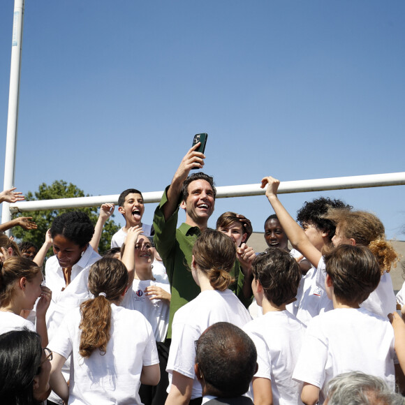 Mika - Le chanteur Mika devient le parrain de la Mêlée des Choeurs et rencontre, des élèves du CM1 à la Terminale qui interpréteront les hymnes nationaux des 48 matchs de la Coupe du Monde de Rugby 2023, à Gennevilliers, France, le 31 mai 2023. La coupe du monde de Rugby en France décroche une star internationale que la France adore en la personne de Mika pour un projet pédagogique et sociétal important unis par la musique. Mika devient le parrain de la Mêlée des Choeurs. Le projet de la Mêlée des Choeurs aura le privilège de compter sur un parrain d'exception : la popstar internationale Mika. La Coupe du Monde de Rugby 2023 a le plaisir d'annoncer que le chanteur Mika sera le parrain de la Mêlée des Choeurs, qui mobilise plus de 7 000 élèves du CM1 à la Terminale, à travers toute la France, pour interpréter les hymnes nationaux des 48 matchs de la Coupe du Monde de Rugby 2023. Artiste complet (auteur, compositeur et interprète) et engagé, véritable citoyen du monde, Mika a rencontré un triomphe planétaire dès 2007, avec l'album Life in Cartoon Motion – les tubes Relax, Take It Easy, Grace Kelly ou encore Love Today en sont extraits – certifié disque de diamant et vendu à plus de 6 millions d'exemplaires partout dans le monde. Suivront quatre nouveaux albums et une farandole de hits qui ont conquis les coeurs, en France comme à l'international : We Are Golden, Rain, Elle me dit, Boum Boum Boum ou encore Keep it simple, sorti en 2023 en duo avec Vianney. 7 000 élèves mobilisés partout en FranceLa collaboration entre Mika et la Mêlée des Choeurs démarrera dès demain, à l'occasion des 100 jours de la Coupe du Monde de Rugby 2023, avec une rencontre organisée avec de jeunes choristes en région parisienne, en présence également d'un Champion du Monde de Rugby. Lancé de concert avec le ministère de l'Education nationale, le ministère de la Culture et la Maîtrise populaire de l'Opéra-Comique, la Mêlée des Choeurs est un projet innovant, à triple dimension artistique, pédagogique et événementielle. Pour la première fois dans l'histoire de la Coupe du Monde de Rugby, des enfants et adolescents scolarisés chanteront les hymnes des équipes participantes au tournoi en étant encadrés par la Maîtrise populaire de l'Opéra-Comique et accompagnés pédagogiquement par leurs enseignants du premier degré et professeurs d'éducation musicale et de chant choral, tous formés à la direction de choeur. Chacun(e) des 7 000 élèves mobilisés par le projet interprétera les deux hymnes d'un match, auquel il assistera ensuite avec les encadrants du choeur. 