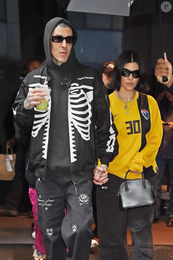 Kourtney Kardashian et son mari Travis Barker se promènent sous la pluie à New York, le 20 mai 2023.