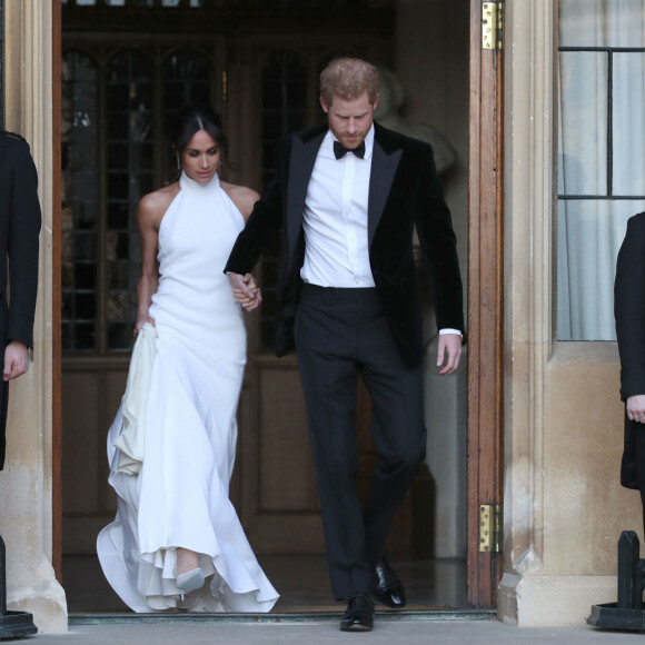 Le prince Harry, duc de Sussex, et Meghan Markle, duchesse de Sussex quittent le château de Windsor à bord d'une Jaguar Type E cabriolet en tenue de soirée après leur cérémonie de mariage, pour se rendre à la réception à "Frogmore House" à Windsor le 19 mai 2018. 