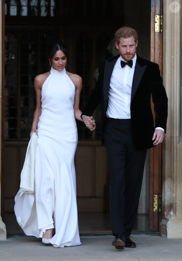 Le prince Harry, duc de Sussex, et Meghan Markle, duchesse de Sussex quittent le château de Windsor à bord d'une Jaguar Type E cabriolet en tenue de soirée après leur cérémonie de mariage, pour se rendre à la réception à "Frogmore House" à Windsor le 19 mai 2018. 