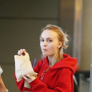 Lily-Rose Depp fait la queue au comptoir "The Coffee Bean" à l'aéroport de Los Angeles, commande puis mange un snack avec une boisson rapidement avant d'aller prendre un avion accompagnée de son garde du corps le 22 mai 2016.