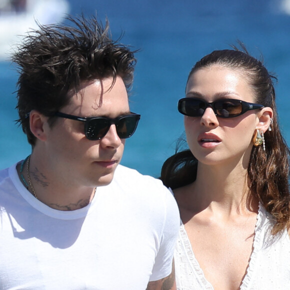 Brooklyn Beckham et sa femme Nicola Peltz, accompagnée de ses parents, arrivent au Club 55 à Saint-Tropez, le 27 juillet 2023. Paré de claquettes-chaussettes, le fils de D.Beckham et V.Beckham, prend sa douce dans ses bras pour débarquer sur la plage. Il a même pris le soin de tendre la main à ses beaux-parents, Nelson et Claudia Heffner Peltz, pour les aider à quitter le Zodiac. 